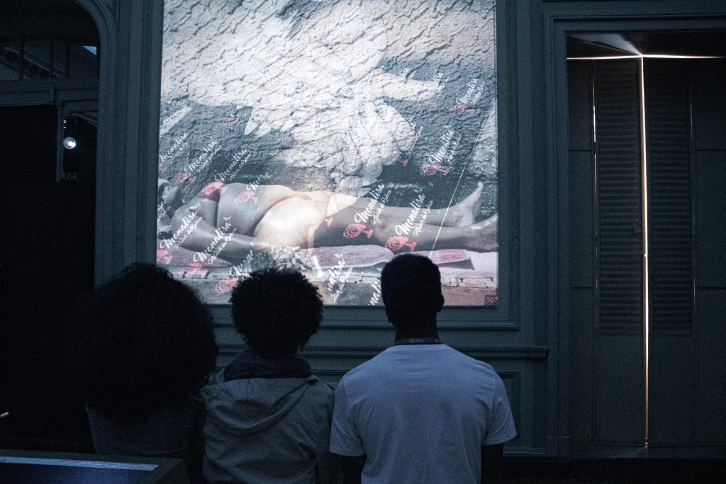 Três jovens negros olhando a exposição.