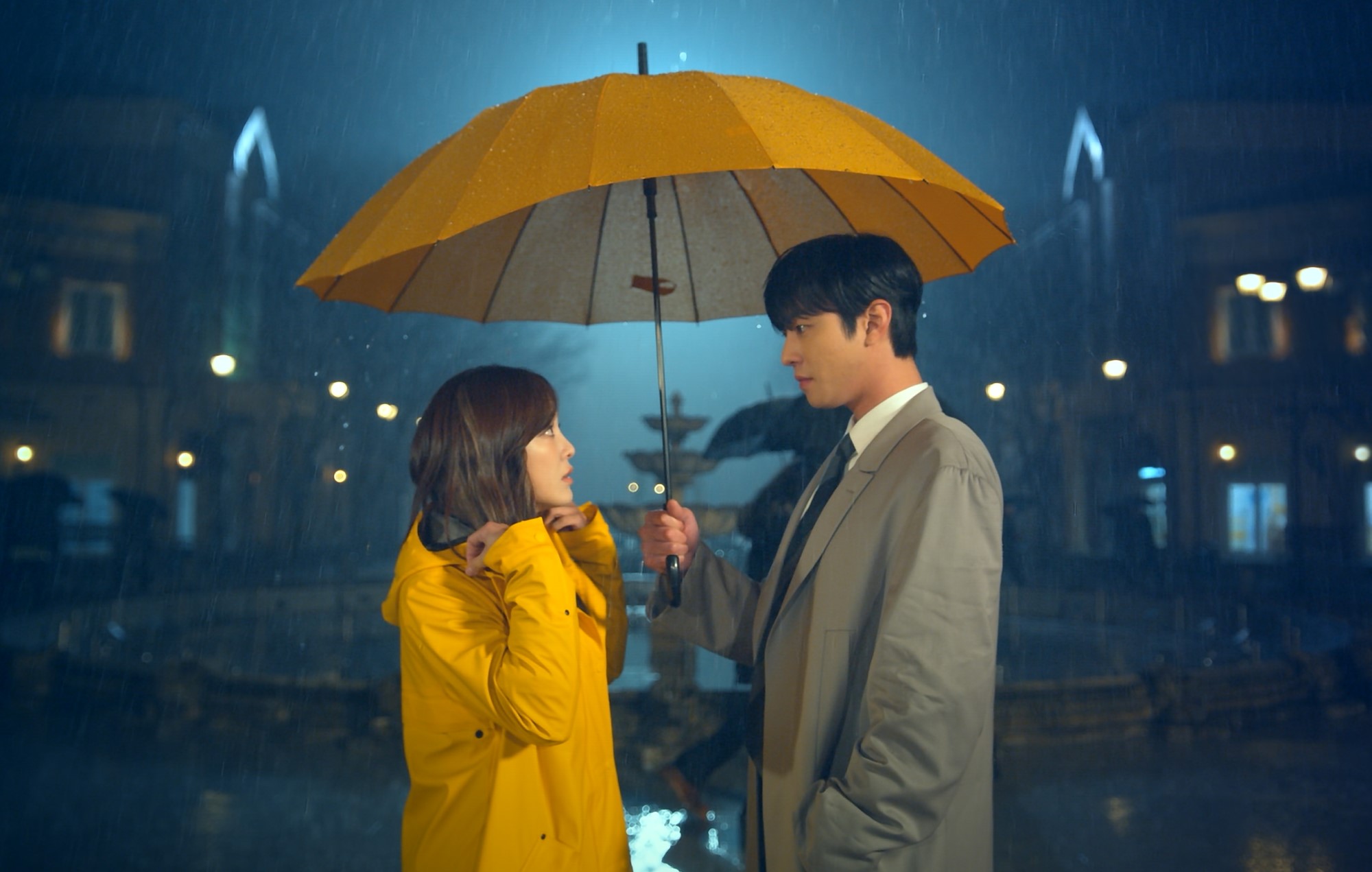 Imagem em que os dois protagonistas de pretendente surpresa estão na chuva, enquanto o protagonista homem segura um guarda chuva