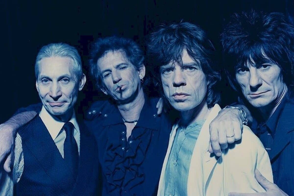 Membros da banda The Rolling Stones posam para a foto, com filtro azul por cima