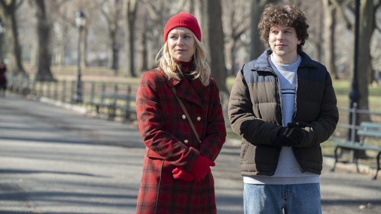 Foto promocional de A Nova Vida de Toby. Na imagem, temos Toby ao lado de uma mulher loira vestida de vermelho. Os dois estão num parque arborizado